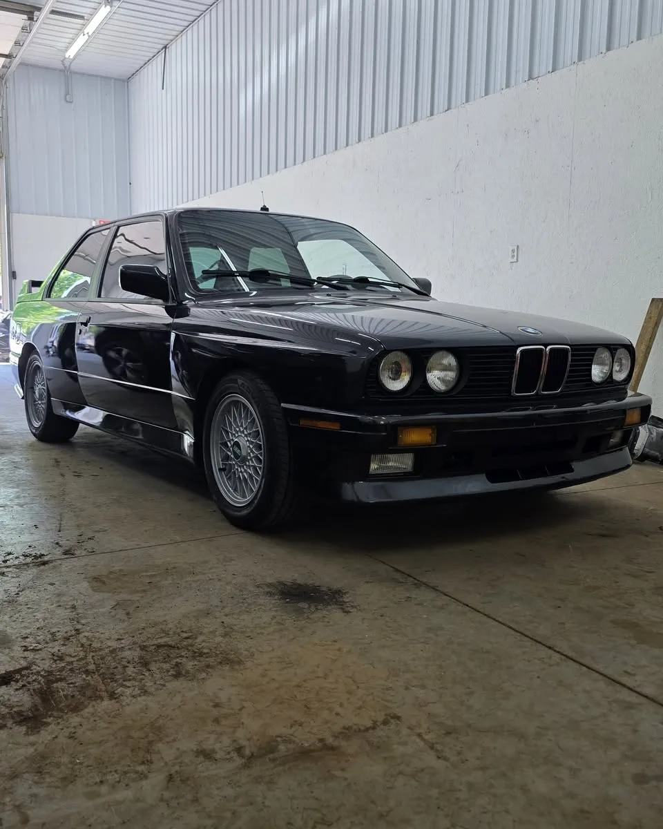 A black BMW E30 M3 in the shop’s bay
