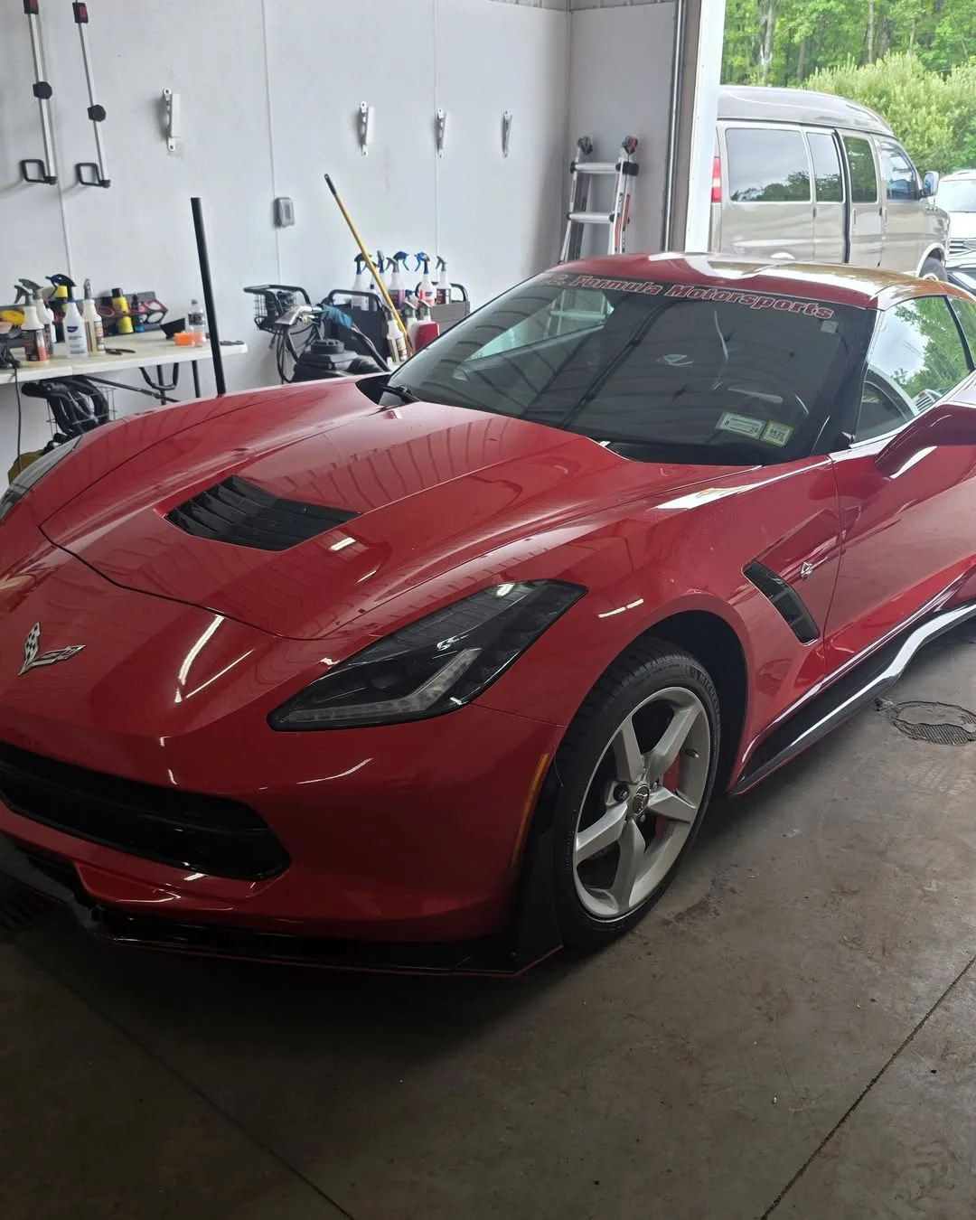 A red C7 Corvette parked in the shop’s bay